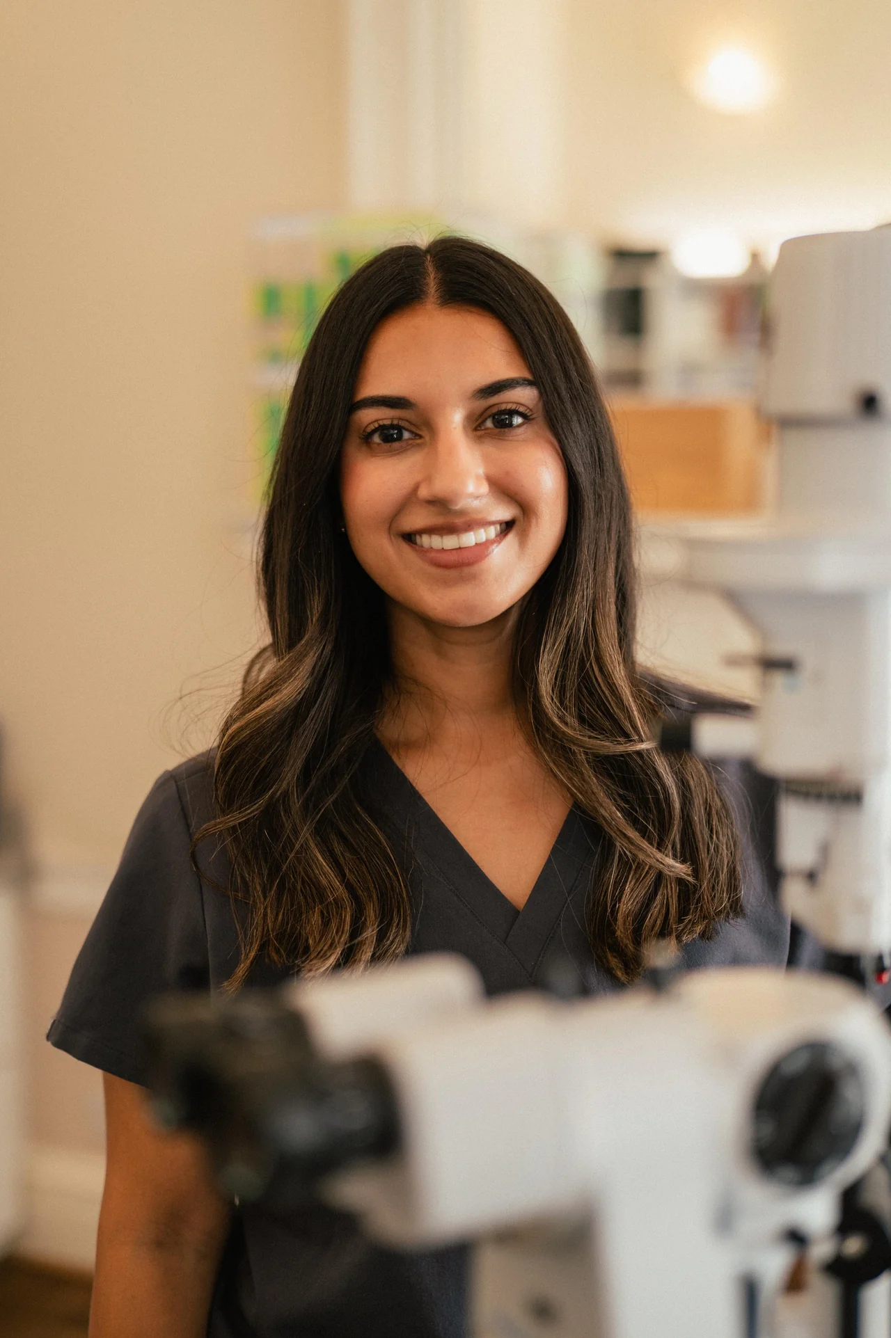 Krupa smiling in the eye clinic, with examination equipment in the foreground